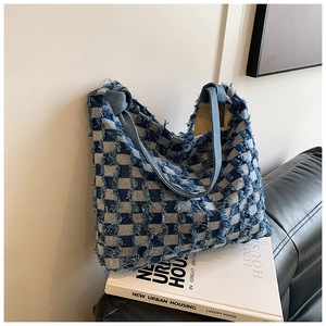 Detail of blue checkerboard denim tote bag showing frayed edges and texture