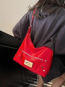 Minimalist red leather tote bag with silver zippers and rivets in motor style