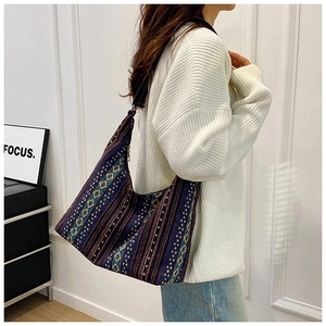 Detalle de un bolso tote de lona bohemio con patrones geométricos tejidos de colores
