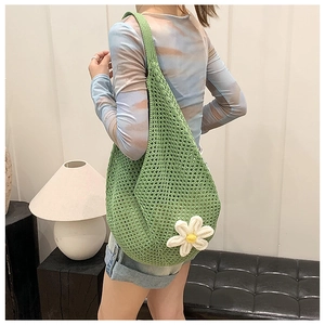 Detailed view of handmade green crochet tote bag with white 3D flower and teardrop design