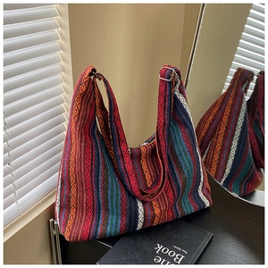 Detalle de bolso tote étnico de tejido colorido con rayas y correa ajustable