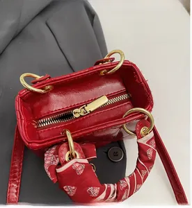 Close-up of the smooth golden zipper and red quilted leather texture on the handbag