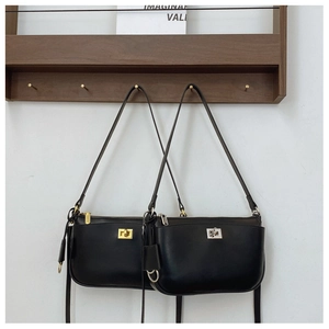 Detail of matte black leather bags with gold and silver square locks on a wooden rack