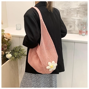 Detail of pink crochet shoulder bag featuring a white daisy and mesh knit pattern
