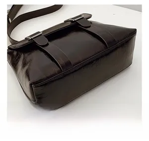 Détail de la base large et durable et des coutures d'un sac bandoulière vintage marron foncé