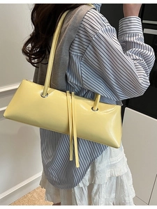 Minimalist light yellow rectangular underarm bag with decorative long leather straps