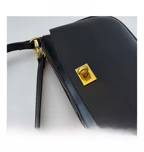 Macro shot of minimalist black leather bag with vintage golden metal twist lock detail