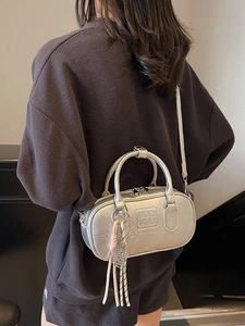 Sac bowling argenté pour femme avec finition métallique et breloque tissée chic