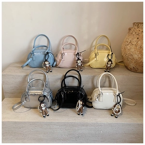 Mini glossy patent leather bowling bags in six vibrant colors with pearl doll charms
