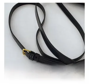 Detail of adjustable black leather shoulder strap with a polished gold pin buckle