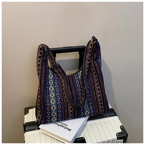 Detalle de bolso tote bohemio con rayas de arcoíris tejidas y correa de hombro ajustable