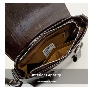 Détails de l'intérieur d'un sac bandoulière en cuir marron avec plusieurs compartiments