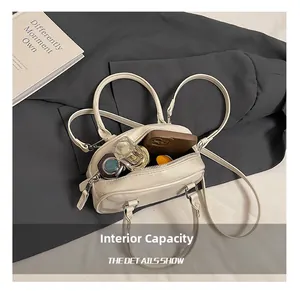 Top view showing the internal capacity of the cream leather bowling bag with daily items