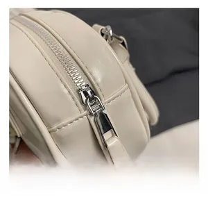 Macro detail of high-quality silver metal zipper and stitching on off-white bowling bag