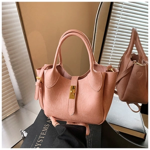 Détail d'un sac seau en cuir rose avec fermoir doré et bandoulière réglable