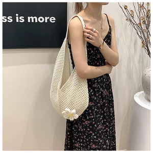 Detail of hollow-out woven shoulder bag with 3D floral decoration in beige white