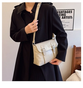 Détail d'un sac à main beige perle avec boucles argentées et texture en cuir lisse
