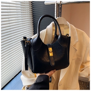 Détail du sac seau noir avec fermoir doré et bandoulière réglable en situation réelle