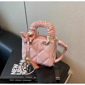 Pink heart quilted handbag featuring a scarf-wrapped handle and elegant pearl charm detail