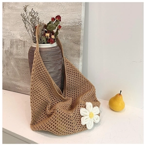 Detail of hand-woven coffee hobo bag featuring a large white daisy crochet flower