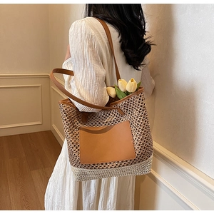 Dettaglio borsa tote in paglia intrecciata con tasca in pelle marrone e trama a rete