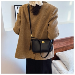 Close-up of a black leather crossbody bag with a gold metal twist lock for daily wear