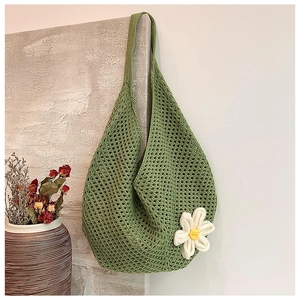 Detail of green woven tote bag featuring a white 3D knit daisy and textured cotton cord