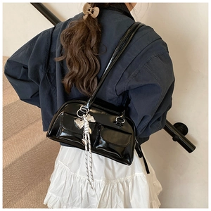 Bolso de hombro de charol negro brillante con bolsillos frontales dobles visto por detrás