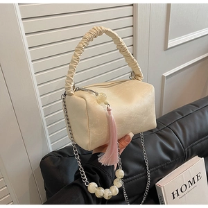 Detail of cream pleated pillow bag with silver chain, marble beads and pink tassel