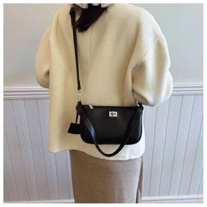 Classic black square bag with silver hardware and adjustable strap on a model