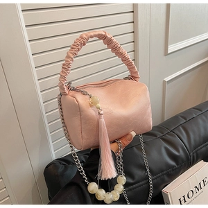 Detailed shot of pink pleated cylinder bag with marble beads and chain strap