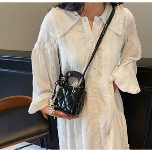 Micro black patent leather quilted bag with silk scarf handle and metal charm detail