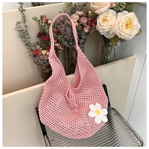 Close-up of pink crochet woven bag with white daisy detail and intricate mesh pattern