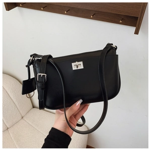 Detail of black crossbody bag featuring a silver twist lock and smooth leather texture