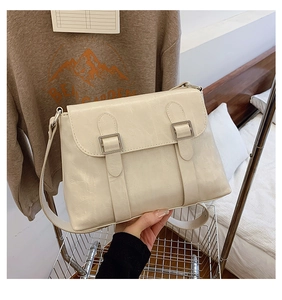 Détail d'un sac bandoulière en cuir PU blanc crème avec boucles argentées sur chariot