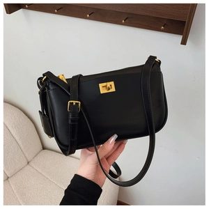 Detail of minimalist black leather crossbody bag with iconic square golden twist lock
