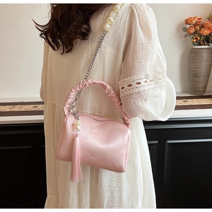 Detailed view of pink ruched pillow bag with floral pattern and pearl chain strap