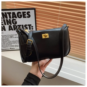 Detail of black matte leather shoulder bag with iconic gold twist lock and metal zipper