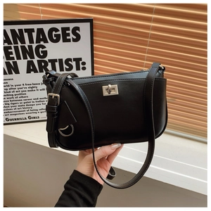 Close-up of black crossbody bag featuring a silver square twist lock and slim shoulder strap