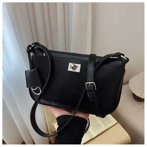 Close-up of black crossbody bag featuring a silver twist lock and adjustable shoulder strap
