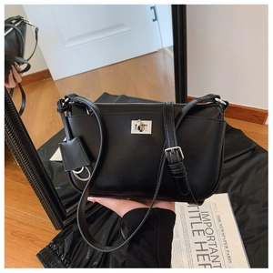 Detail of black crossbody bag with silver metal swivel lock and adjustable strap