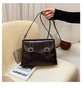 Vue détaillée du sac en cuir brillant marron foncé avec doubles boucles argentées