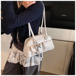 Detalle de bolso Boston blanco con colgante de corazón y prácticos bolsillos frontales
