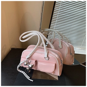 Detalle del bolso Boston rosa y blanco con colgante de lazo plateado y dos bolsillos front