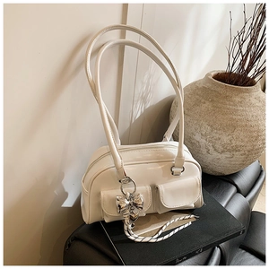 Detalle de bolso de hombro blanco brillante en ecopiel con dos bolsillos y adorno de metal