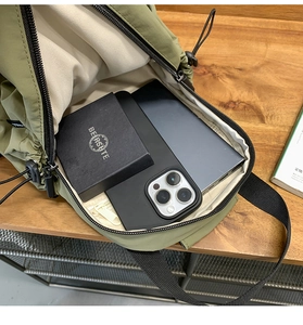 Detail view of the spacious inner compartment of the green waterproof nylon chest bag