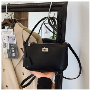 Detail showing matte black crossbody bag with silver twist lock and adjustable strap
