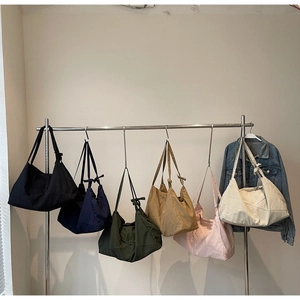 Minimalist canvas tote bags in six colors hanging on a rack for a relaxed lifestyle look
