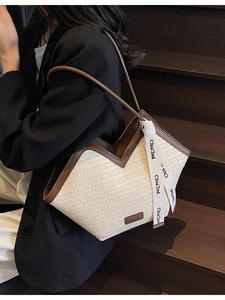 Chic beige woven straw tote bag with brown leather trim and stylish logo ribbon detail