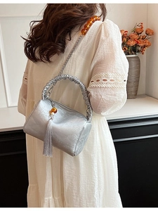 Silver pleated shoulder bag with chain strap and amber bead detailing for a modern look